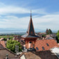 Toiture Willy, ferblanterie en rénovation avec vue sur la cloche, l'église, le lac, le village et les montagnes