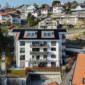 Vue sur les panneaux solaires, le balcon et fenêtre de toit d'un immeuble réalisé à Chexbres, Vaud