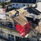 Vue sur le toit en construction et sur le panneau publicitaire de Toiture Willy